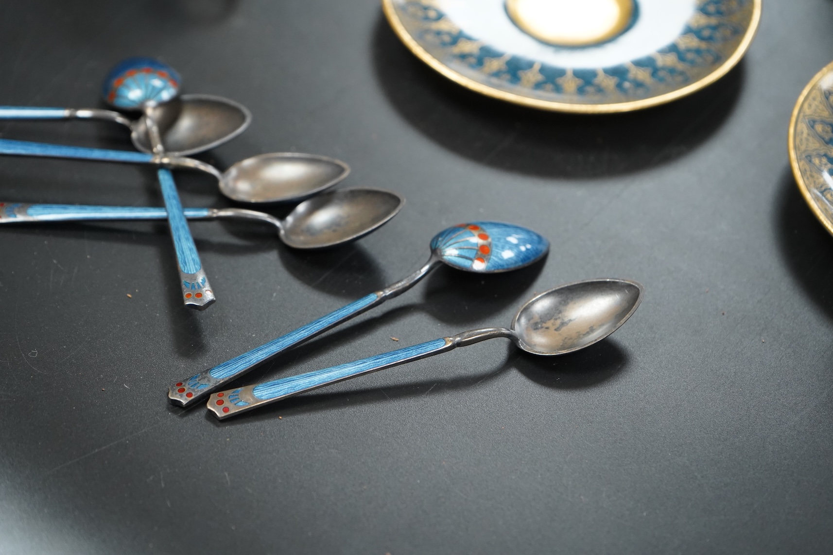 A set of six Royal Worcester cups and saucers, powder blue and gilt decoration, together with a set of six silver and enamel teaspoons